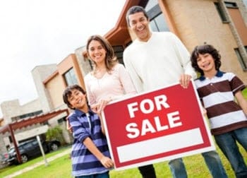 Sell my house - young family in front a house for sale sign